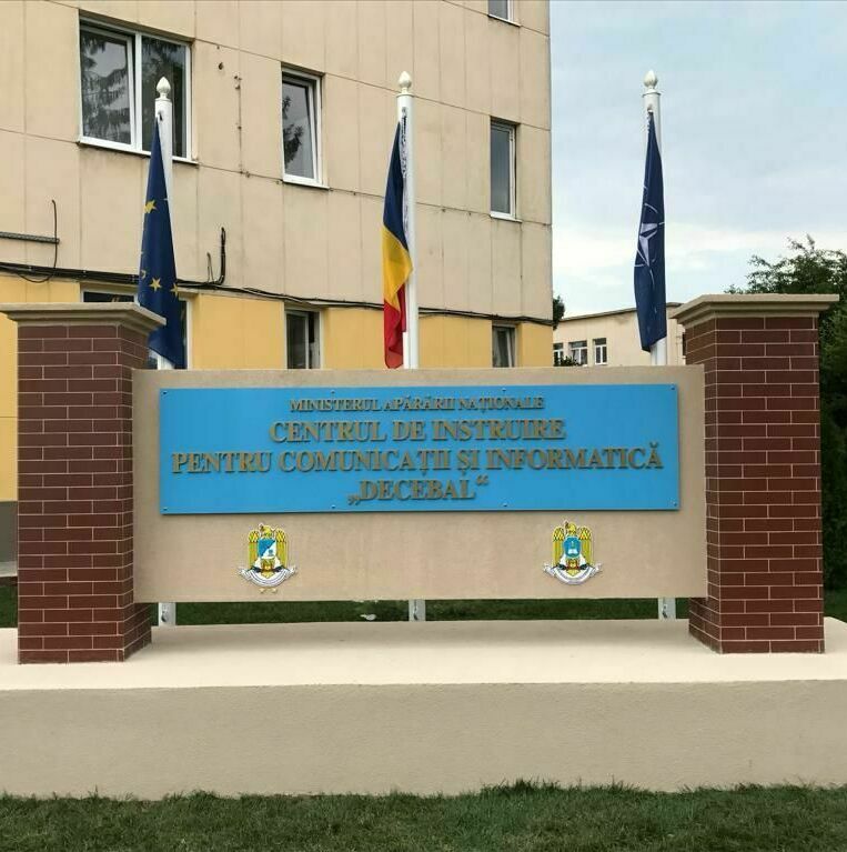 Totem podium personalizat pentru Armata României, cu litere volumetrice și steaguri integrate, amplasat pe fundație de beton și cărămidă