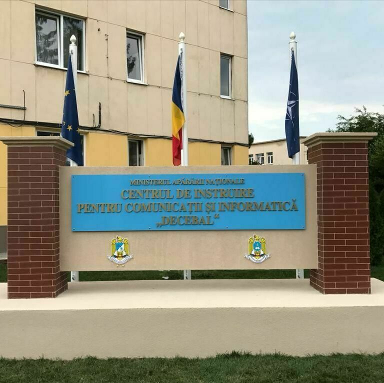 Totem podium personalizat pentru Armata României, cu litere volumetrice și steaguri integrate, amplasat pe fundație de beton și cărămidă
