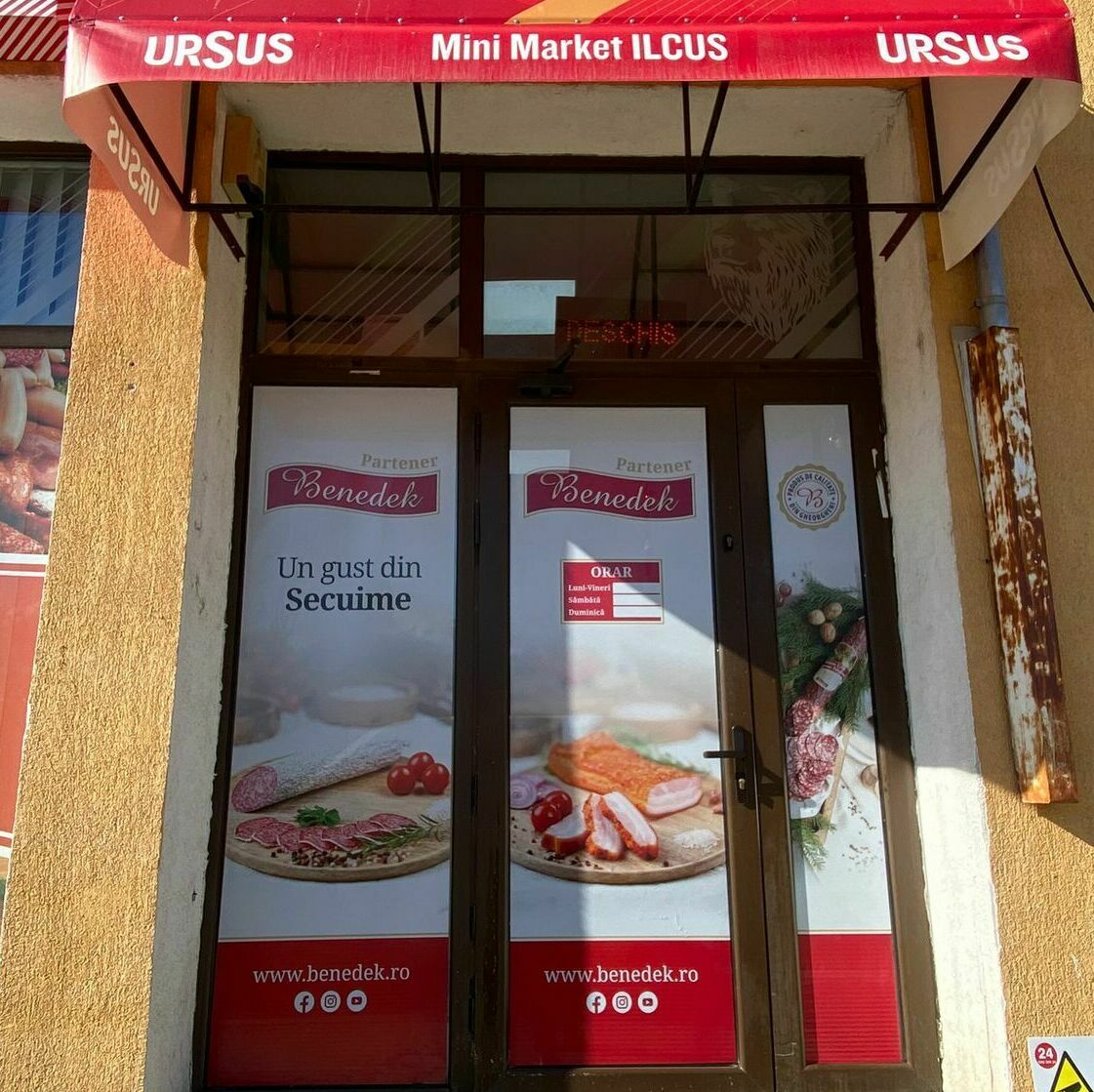 Decorarea intrării magazinului de carne din Sibiu cu autocolant printat și perdea printată, design personalizat și atrăgător.