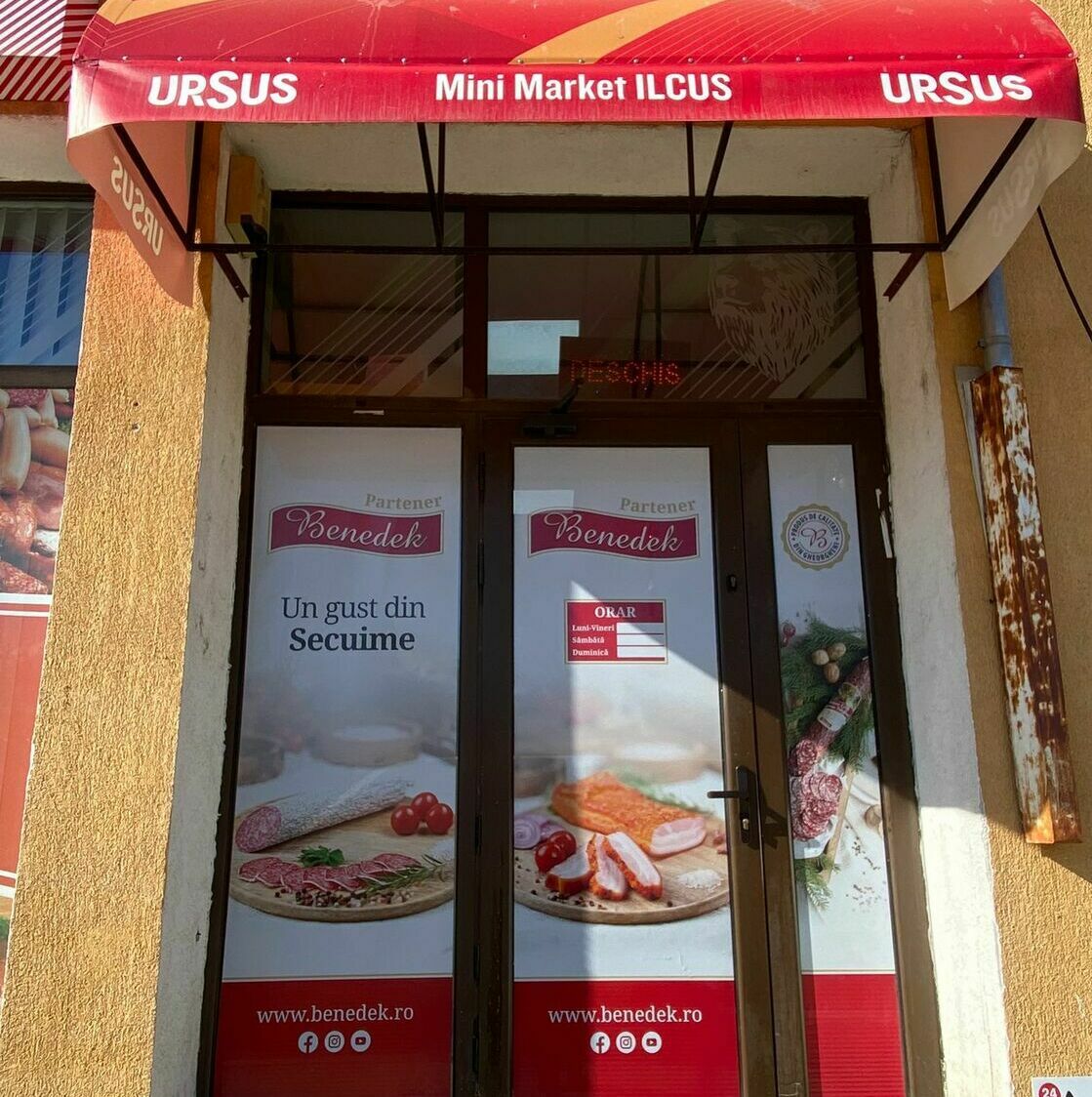Decorarea intrării magazinului de carne din Sibiu cu autocolant printat și perdea printată, design personalizat și atrăgător.