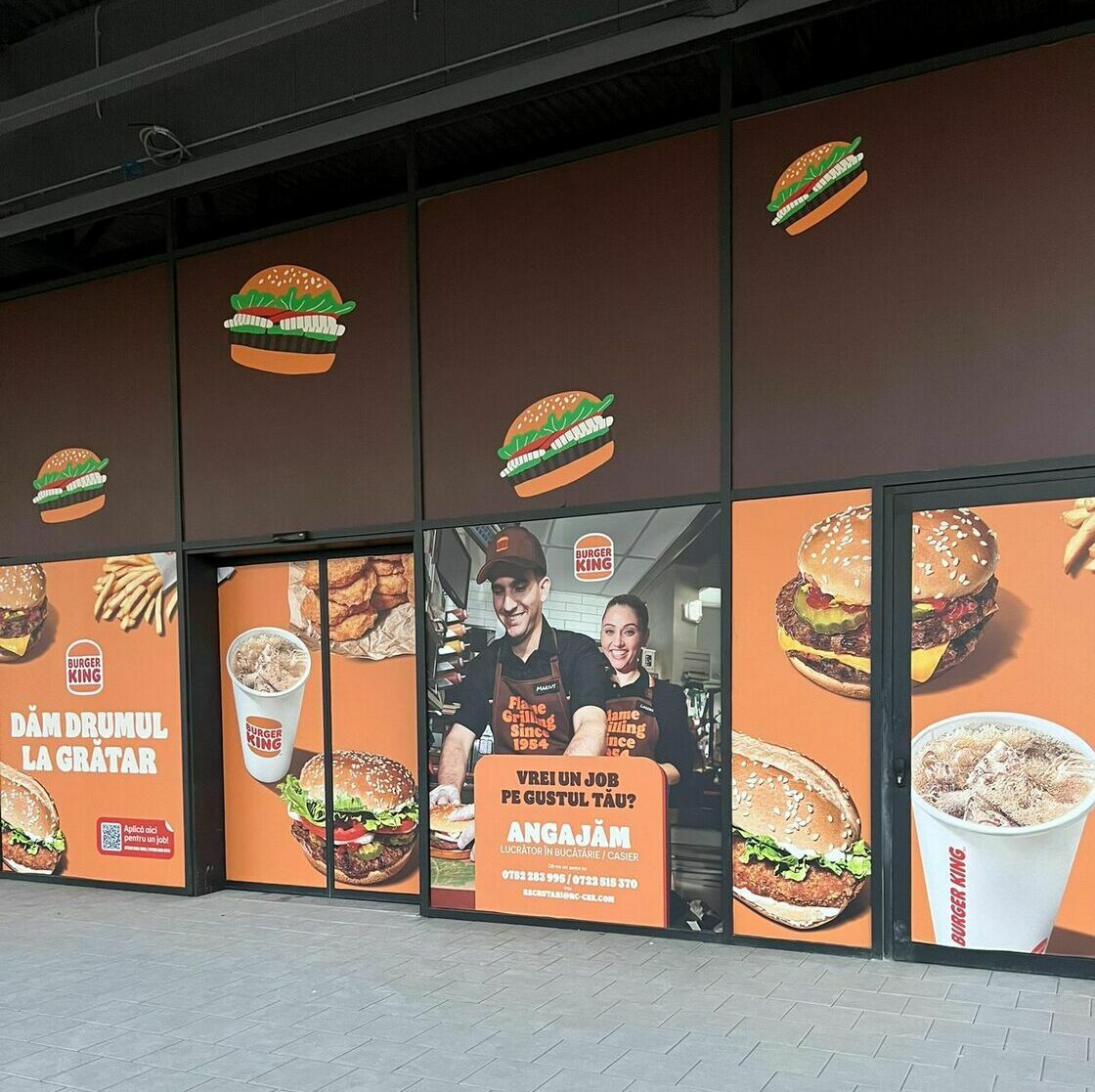Imbracarea fațadei unui mare mall în autocolant și mesh pentru renumitul Burger King, incluzând printare, grafică și montaj profesional