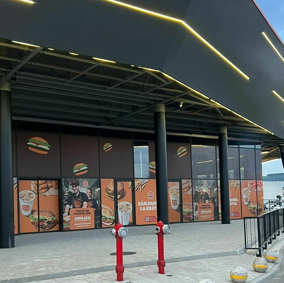 Implementarea unei soluții vizuale de impact pentru fațada unui mall important, prin aplicarea autocolantului și mesh-ului personalizat pentru renumitul lanț Burger King, incluzând procese meticuloase de printare, design grafic și montaj profesionist.