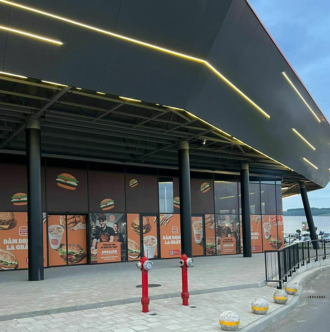 Implementarea unei soluții vizuale de impact pentru fațada unui mall important, prin aplicarea autocolantului și mesh-ului personalizat pentru renumitul lanț Burger King, incluzând procese meticuloase de printare, design grafic și montaj profesionist.