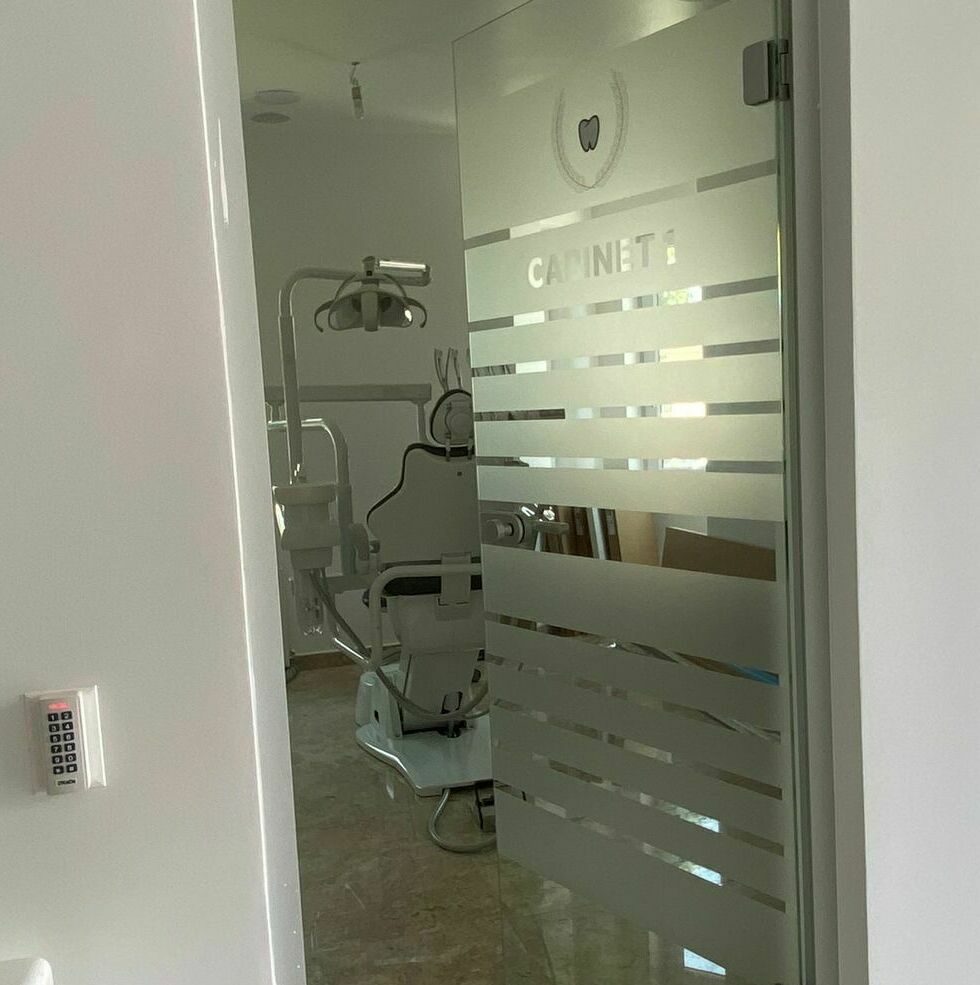 Aplicare folie sablată pentru decorarea geamului în cel mai mare cabinet stomatologic din Sibiu, design interior personalizat și elegant.